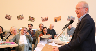 Gäste der Feier im Hinetrgrund, Martin Roswski am Redepult. 