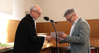 Dr. Claus Müller überreicht Urkunde an Gerd Kiefer