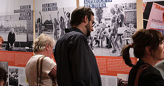 Mehrere Personen stehen vor Ausstellungstafeln