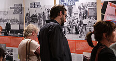 Mehrere Personen stehen vor Ausstellungstafeln