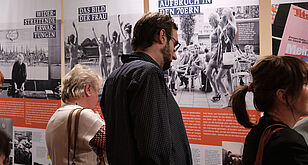Mehrere Personen stehen vor Ausstellungstafeln
